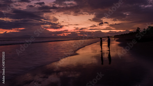 Beautiful aerial view of the magical sunset and the silhouette of a kid and his dad in Puntarenas Costa Rica