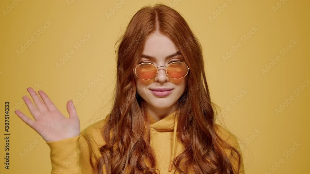 Redhead girl waving hand in studio. Female person showing no sign indoors