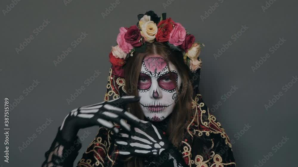 woman in death image, sugar Mexican skull, flirtatiously posing for the camera. halloween makeup