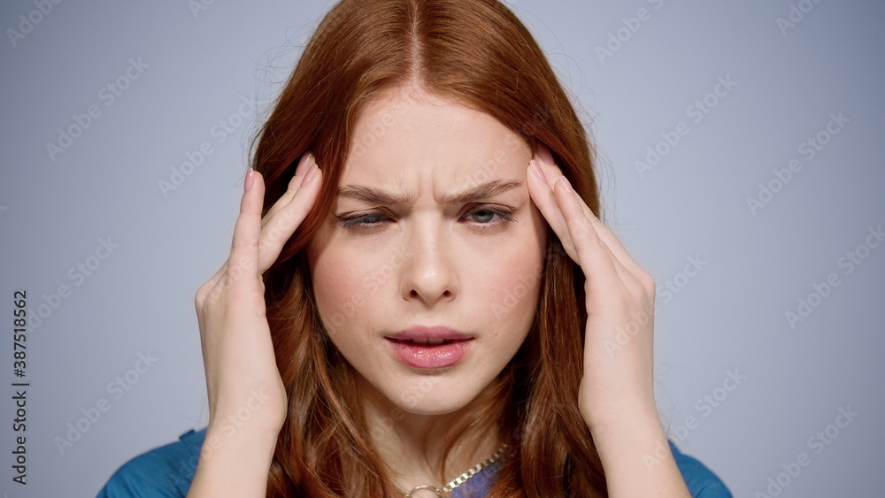 Apathetic woman having headache indoors. Sad girl suffering from ache in studio Apathetic woman having headache indoors. Sad girl suffering from ache in studio