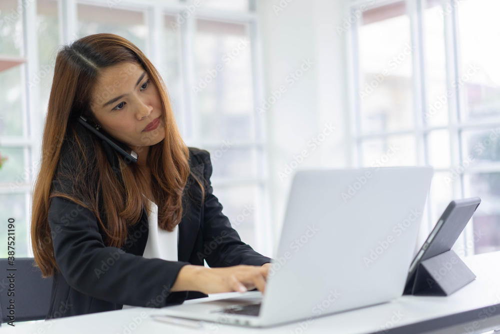 close up young businesswoman typing on laptop to check e-mail or create report during use smartphone to talk with manager or customer for multitasking and busy job concept close up young businesswoman typing on laptop to check e-mail or create report during use smartphone to talk with manager or customer for multitasking and busy job concept