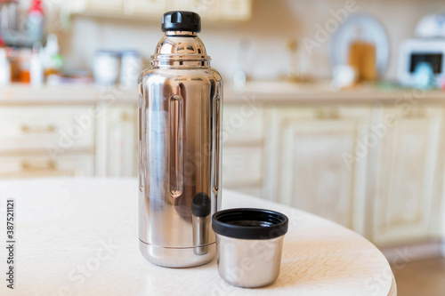 Close-up of steel thermos on white kitchen table