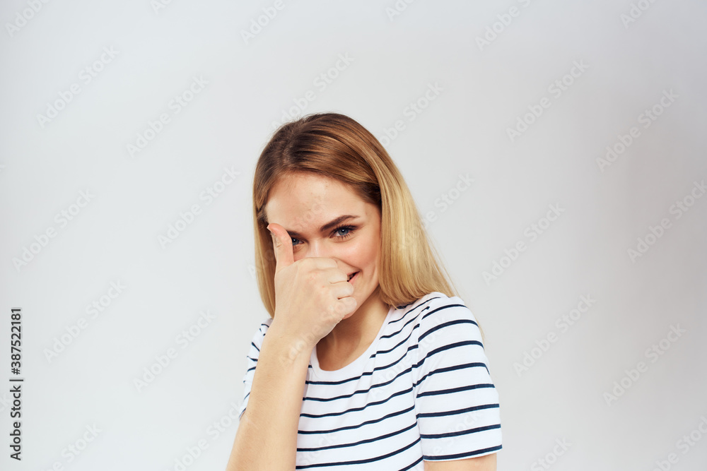 emotional woman in striped t-shirt gesture with hands lifestyle light background emotional woman in striped t-shirt gesture with hands lifestyle light background