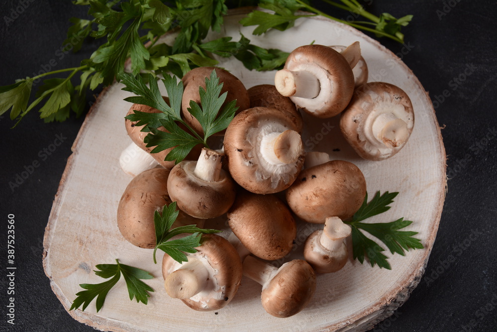 Fresh brown champignon mushrooms on wooden board Fresh brown champignon mushrooms on wooden board