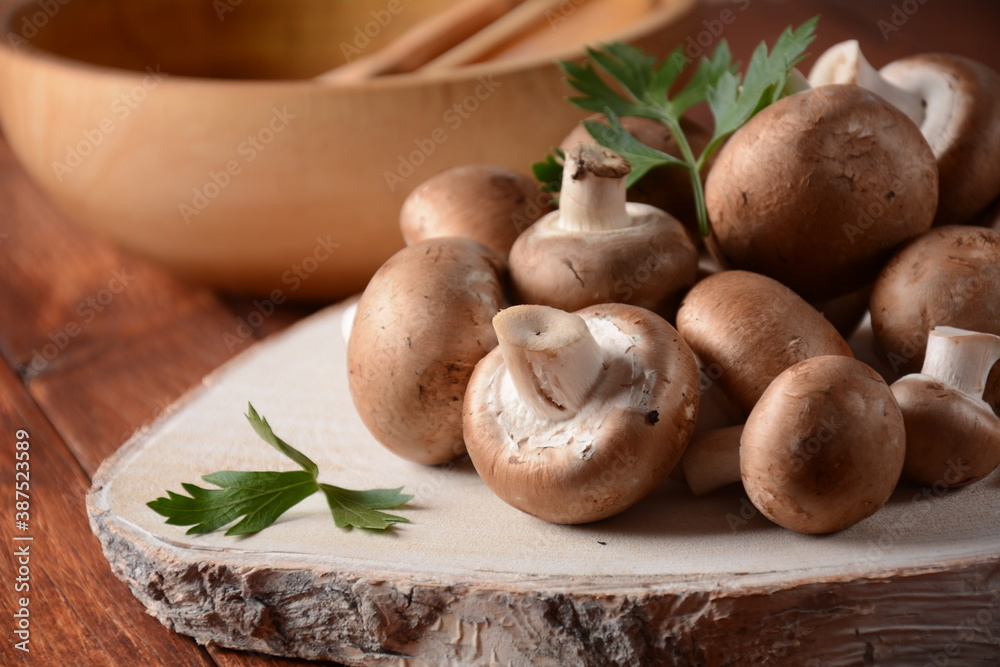 Fresh brown champignon mushrooms on wooden board Fresh brown champignon mushrooms on wooden board
