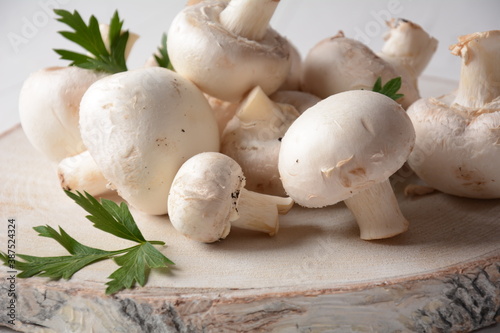 Fresh white champignon mushrooms on wooden board