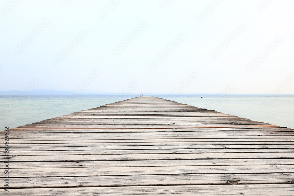 The view along a wooden pier from the resort town of Sirmione on the banks of Lake Garda in north east Italy.