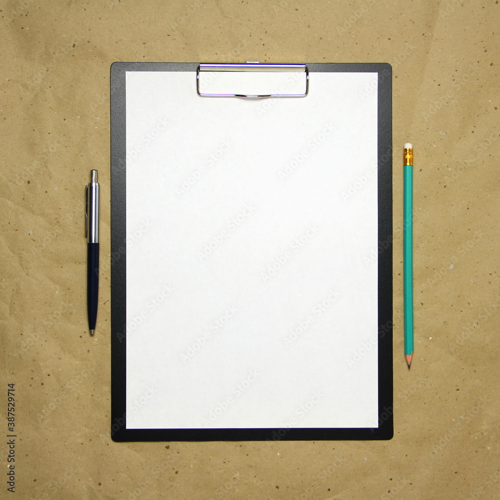 A tablet with a white sheet of A4 format on a beige craft paper.