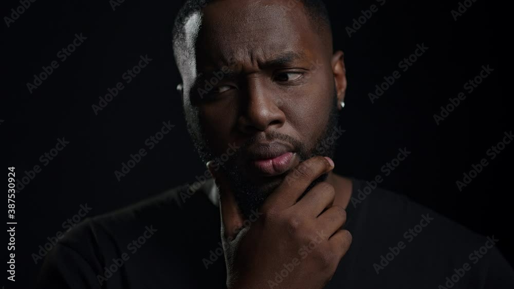 Doubtful afro guy getting an idea indoors. Portrait of thinking african man Doubtful afro guy getting an idea indoors. Portrait of thinking african man