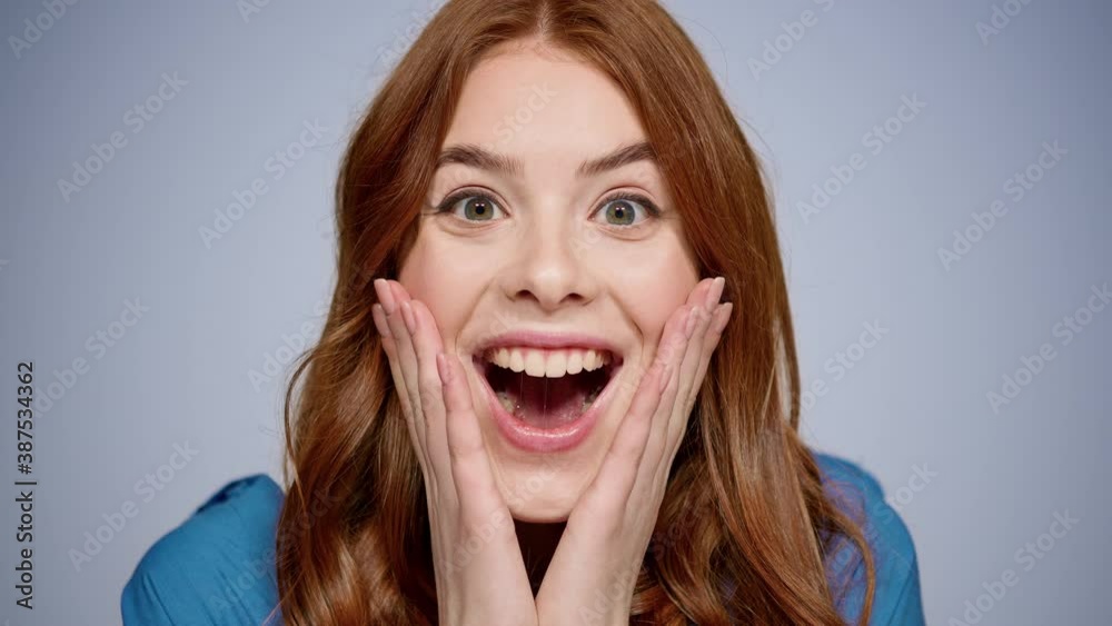 Joyful girl making hand gestures in studio. Female person touching face indoors Joyful girl making hand gestures in studio. Female person touching face indoors