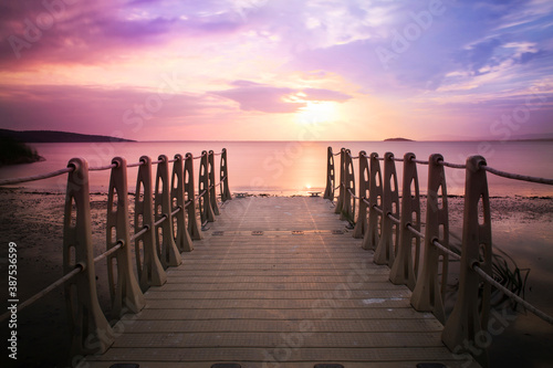 Sunset long exposure shot with plastic pier and cloudy purple and orange sky