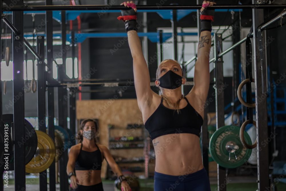 Chicas con mascarilla en un gimnasio realizando Cross training Chicas con mascarilla en un gimnasio realizando Cross training