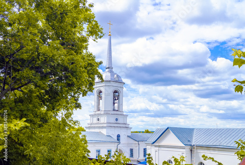Church steeple Orthodox monastery. A tower with domes, a cross and a tree against a blue sky. The Church belfry.
