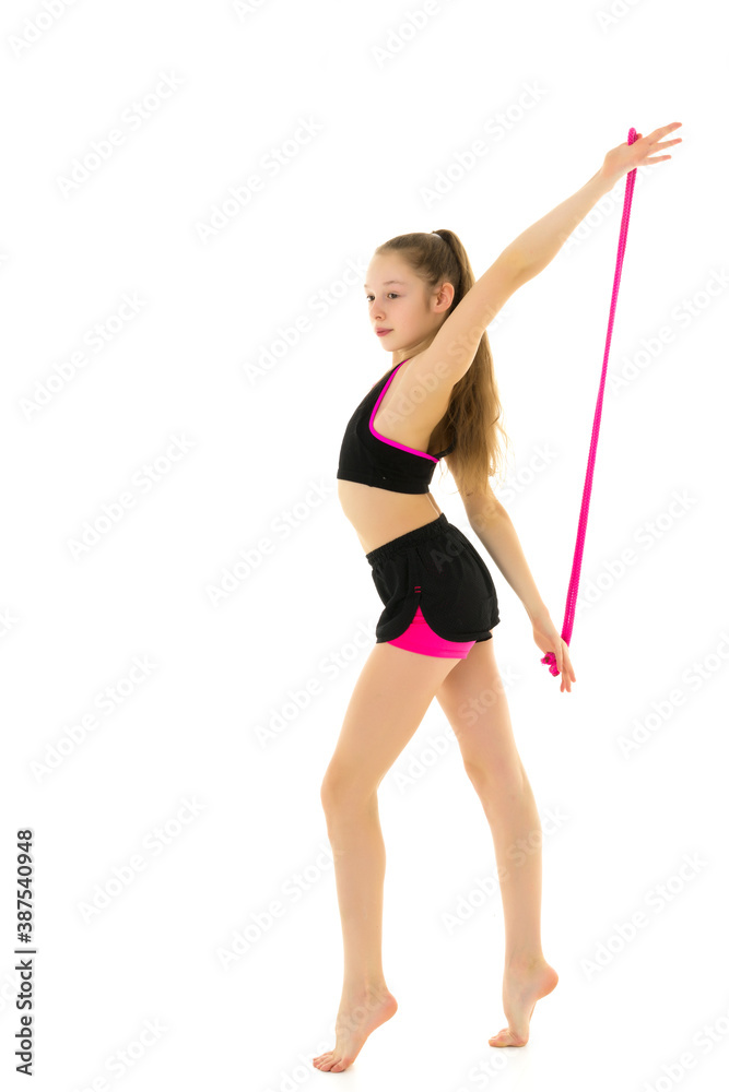 A girl gymnast performs exercises with a skipping rope. A girl gymnast performs exercises with a skipping rope.