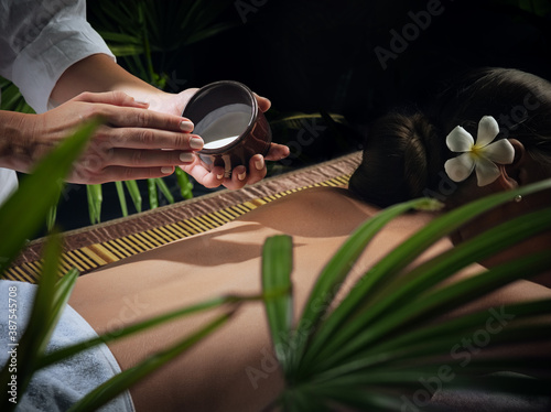 oil massage fragment of young beautiful woman in spa environment.   photo