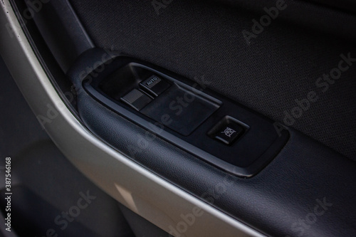 Сlose-up of the car black interior: the side door buttons: window adjustment buttons, door lock and other buttons.