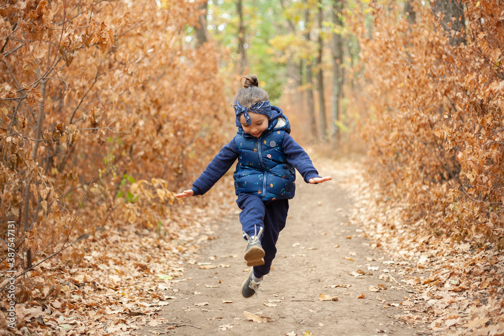 A little girl runs through the forest. The girl is having fun in the forest. A little girl runs through the forest. The girl is having fun in the forest.
