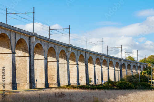 Arches of the viaduct to the Loing canal bridge with railroad and overhead line. Seine-et-Marne department, Ile-de-France region, France.