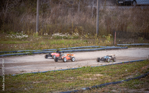 Three RC buggies racing on an outdoor offroad track