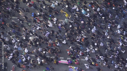 Aerial top view of flash mobs protesters demonstration rally on street road against government, crowd of people in Bangkok City, Thailand in public for democracy. Politics concept. Insurrection.
