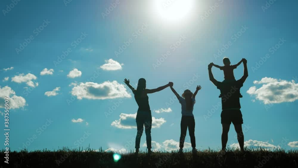 Happy young family together with two children at sunset. People silhouettes on summer sunset meadow. Concept of friendly family. Happy young family together with two children at sunset. People silhouettes on summer sunset meadow. Concept of friendly family.