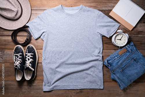 Mockup of a gray t-shirt blank shirt template with accessories on the table background, lifestyle and travel concept photo