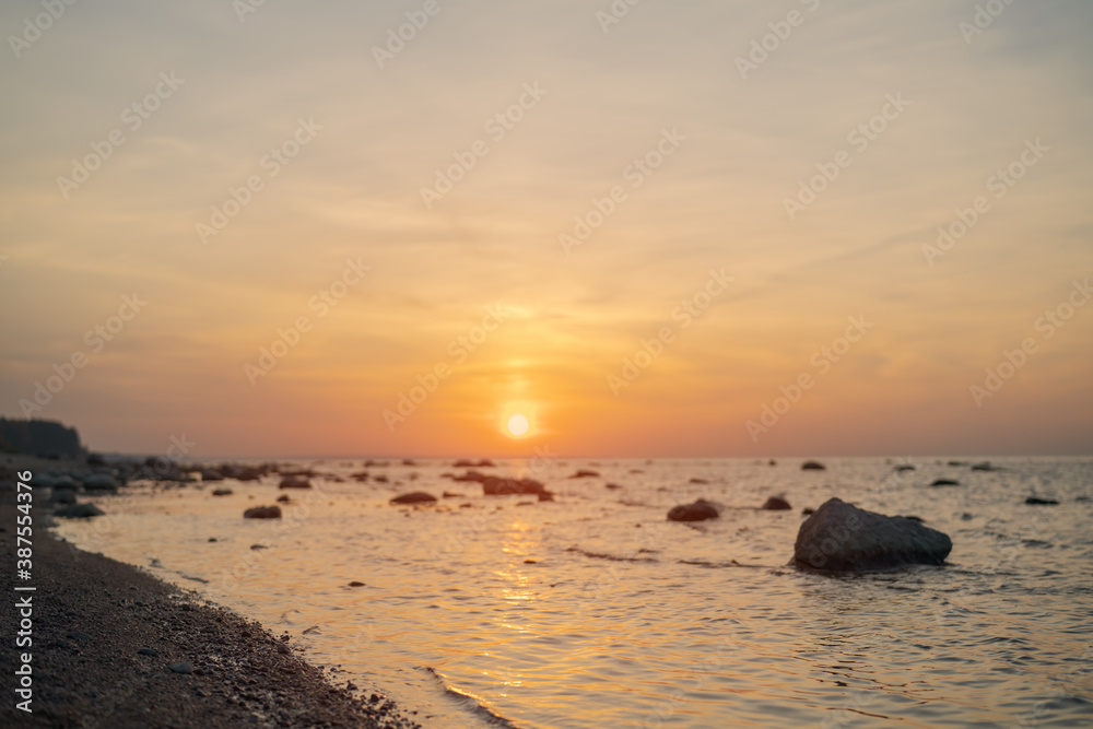 Sunset on baltic sea beach with rocks in sand Sunset on baltic sea beach with rocks in sand