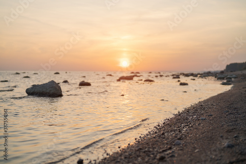 Fototapeta Naklejka Na Ścianę i Meble -  Sunset on baltic sea beach with rocks in sand