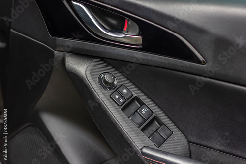 Car arm rest with Control Panel. Door Lock & Mirror Control. window adjustment buttons, door lock. Photography of a modern car.