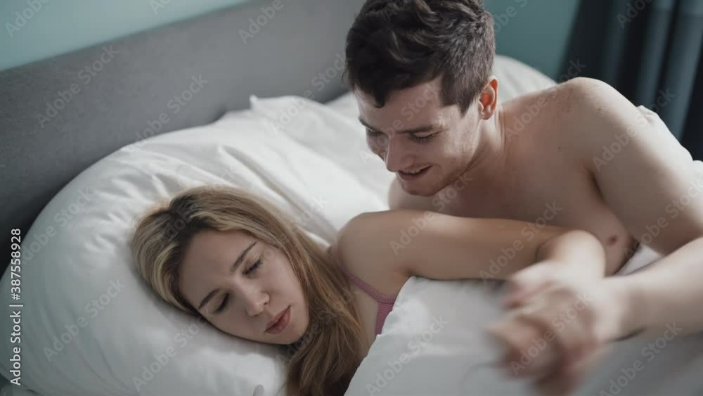 Upset pair of lovers lying on the bed. Family conflict. Woman having a headache doesn't want to have intimacy with her boyfriend. Crisis in relations. Divorce, marriage concept. Filmed on RED camera