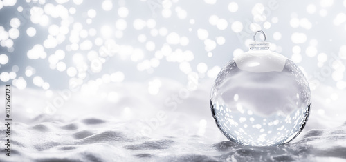 Empty Christmas glass ball on snow.
