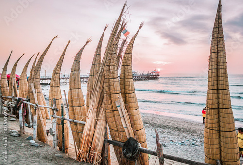 The view to the caballitos de totora ( totora horseboat) on the sunset at huanchaco beach in the peruvian coast near trujillo - Peru photo