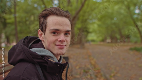 Young man freelancer student using laptop studying online working from park in internet, smiling focused millennial guy typing on computer surfing web looking at screen enjoying distant job