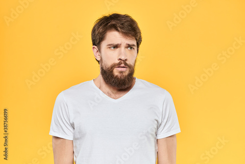Bearded man emotions gestures with hands facial expression white t-shirt yellow background © SHOTPRIME STUDIO