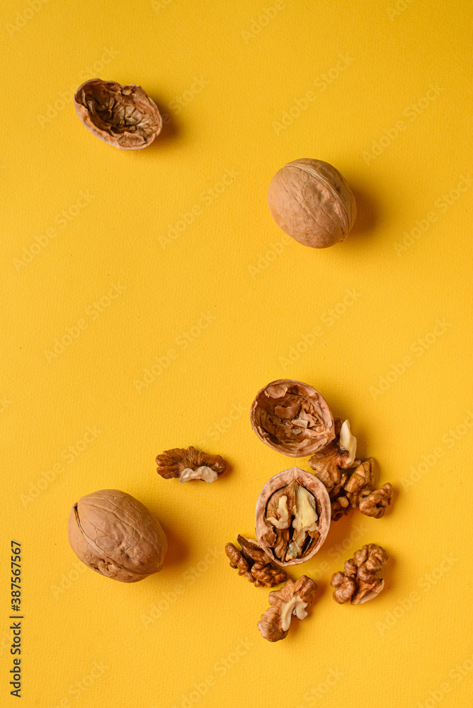 Walnuts on a bright yellow plain background Walnuts on a bright yellow plain background