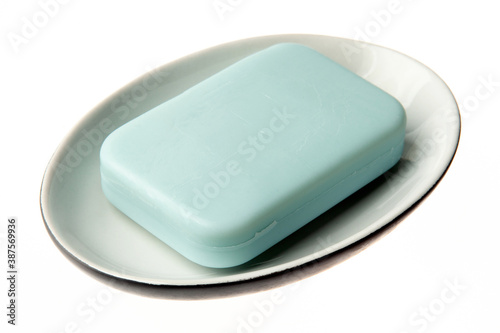 A bar of natural blue soap in a soap plate isolated on white background. Studio shot. Hygiene theme - bacteria and virus prevention