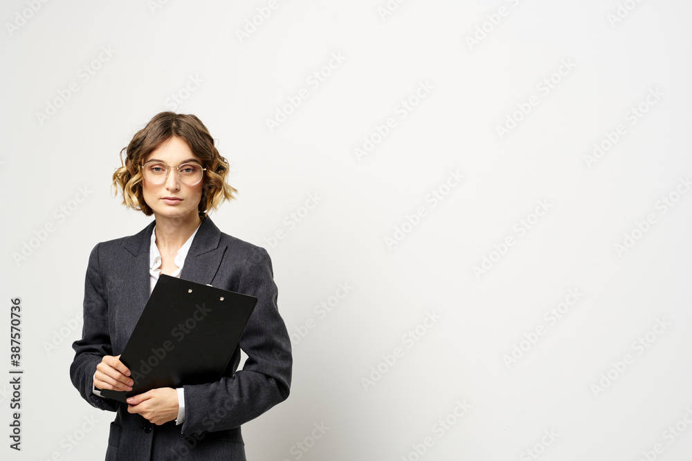 business woman in a suit with documents in hands light background curly hair hairstyle business woman in a suit with documents in hands light background curly hair hairstyle