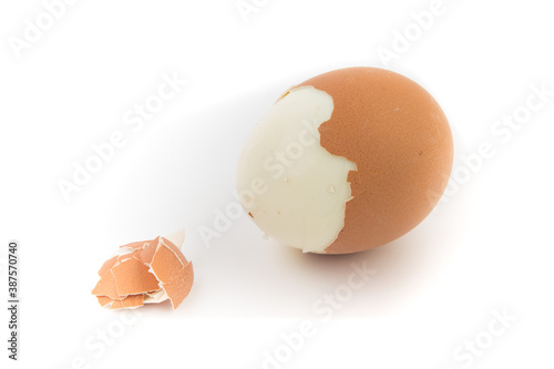 Egg with broken shell closeup on white background.