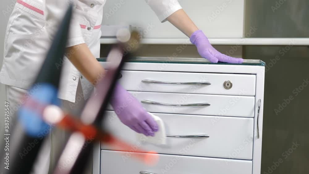 Dental tools being cleaned by female assistant in modern dental clinic