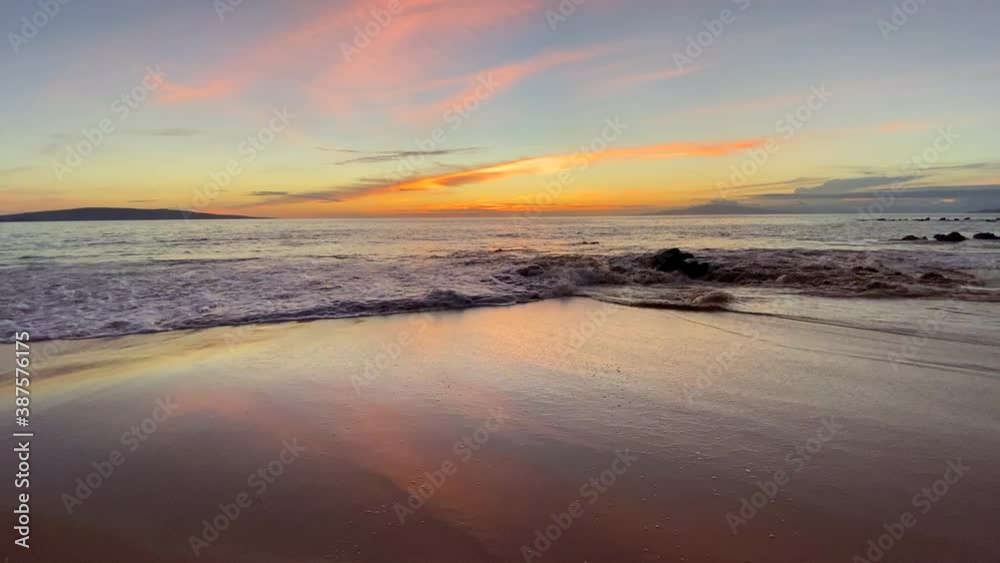 Hawaii beach sunset with gentle waves rolling to reflective shore. Hawaii beach sunset with gentle waves rolling to reflective shore.
