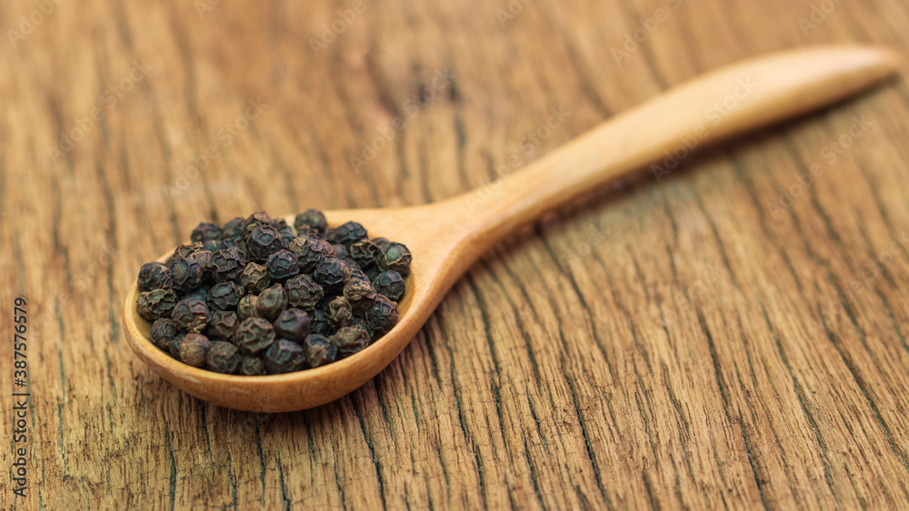 Close Up of peppercorn in wooden spoon on old wooden table. Close Up of peppercorn in wooden spoon on old wooden table.