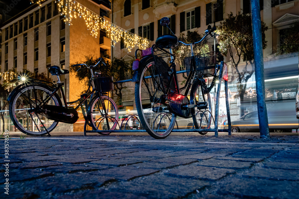Bicycles along the street at night