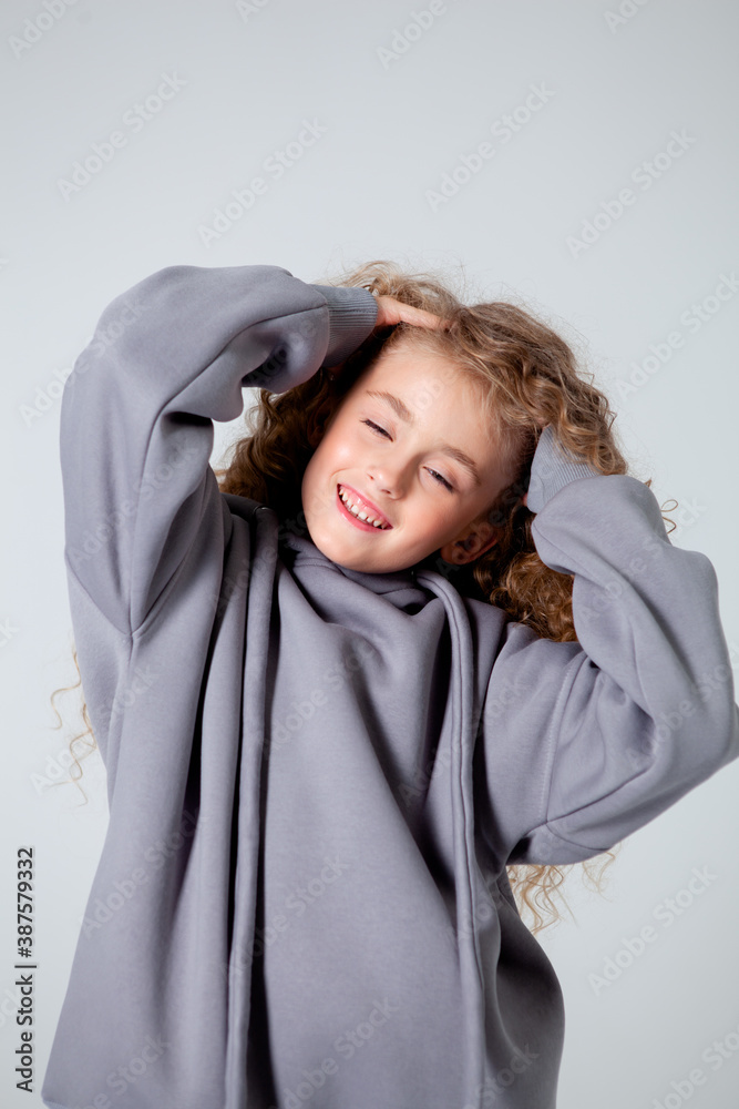 curly girl in a white long sleeve t-shirt stands curly girl in a white long sleeve t-shirt stands