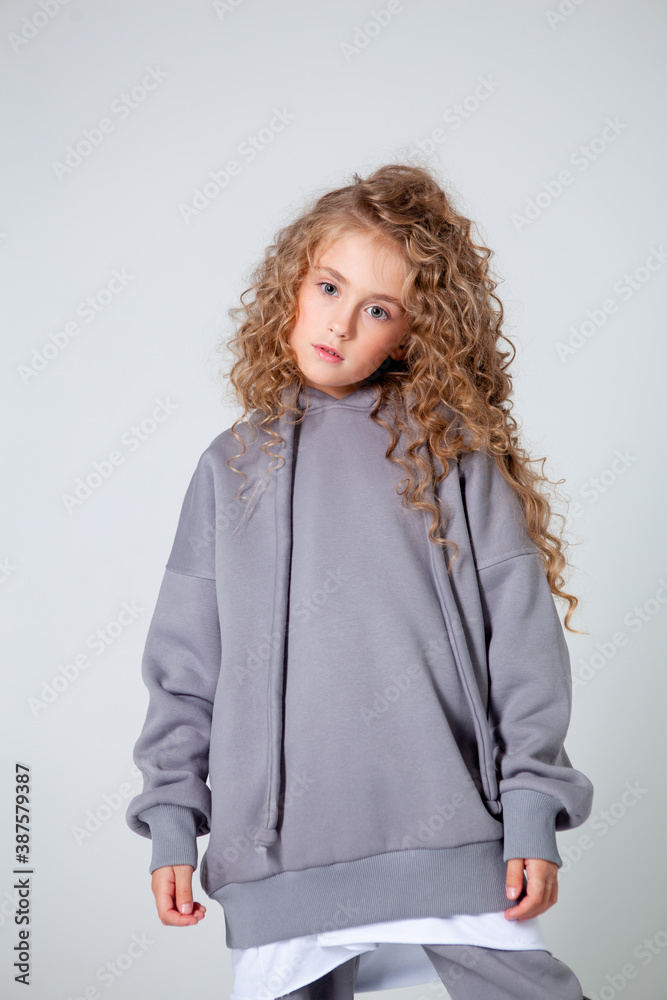 curly girl in a white long sleeve t-shirt stands curly girl in a white long sleeve t-shirt stands