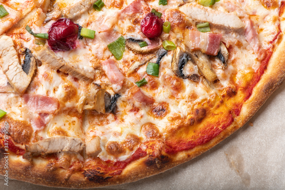 Delicious italian pizza with cheese mozzarella , tomatoes, bacon, mushrooms and green onion. Partial top view, close up. Delicious italian pizza with cheese mozzarella , tomatoes, bacon, mushrooms and green onion. Partial top view, close up.