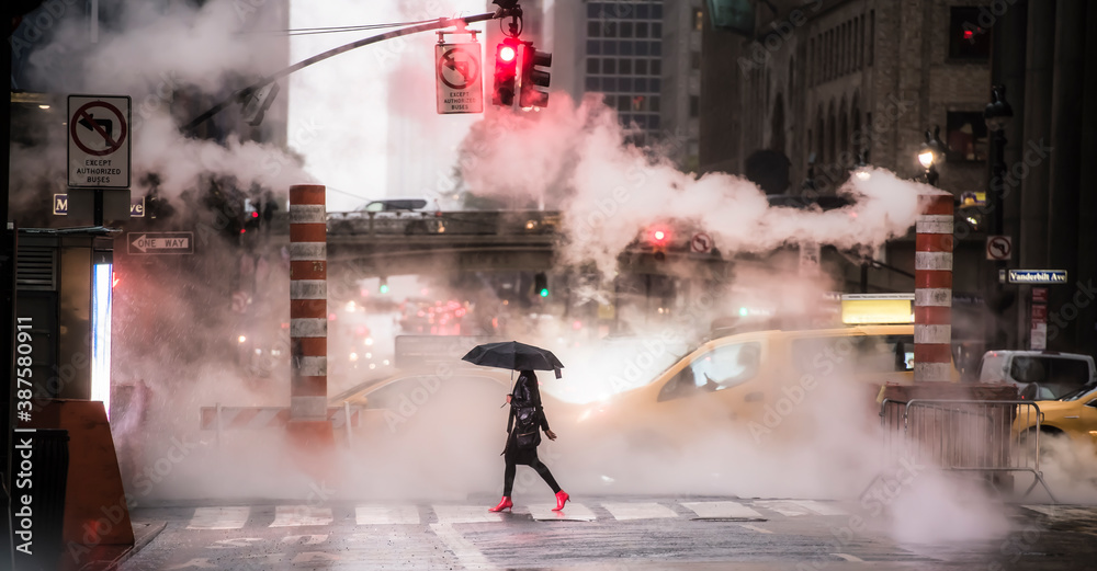 A woman wearing red high heels is crossing the 42nd street in Manhattan during the Covid-19 outbreak. Manhattan, New York City, United States.