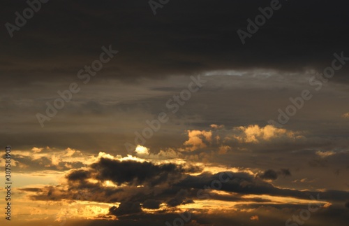 Grey cloudy sky with golden sunbeams