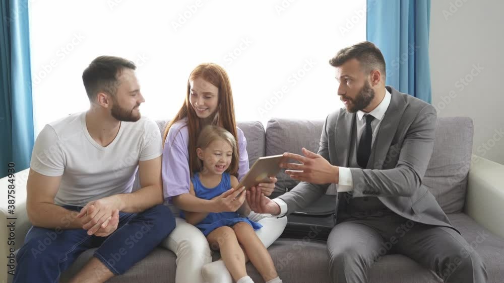 Real estate agent came at home to married couple, they sit discussing possible getting of mortgage, sit on sofa at home. Real estate agent came at home to married couple, they sit discussing possible getting of mortgage, sit on sofa at home.