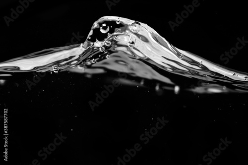 Water waves and splash isolated on black background, side view