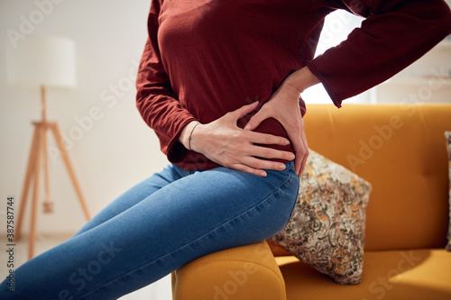 Woman with strong hip pain at home.
